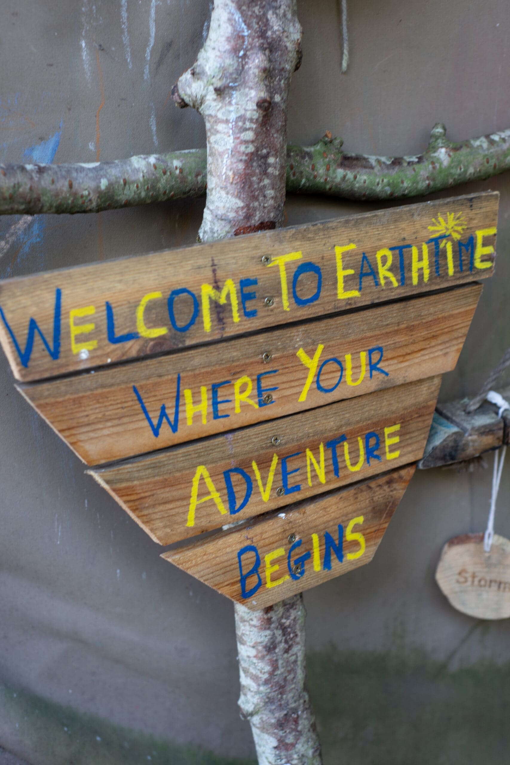 Wooden sign which reads Welcome to Earthtime where your adventure awaits.